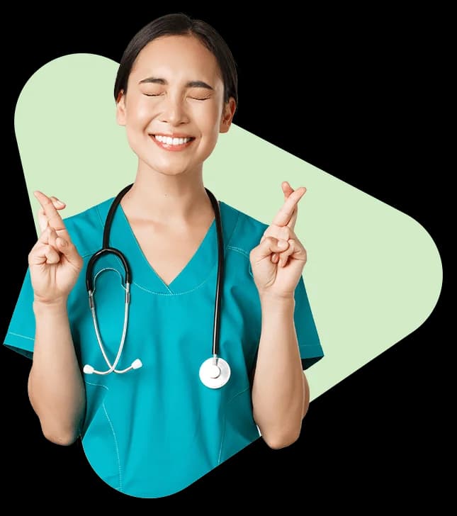 Medical professional in teal scrubs with stethoscope, smiling with crossed fingers